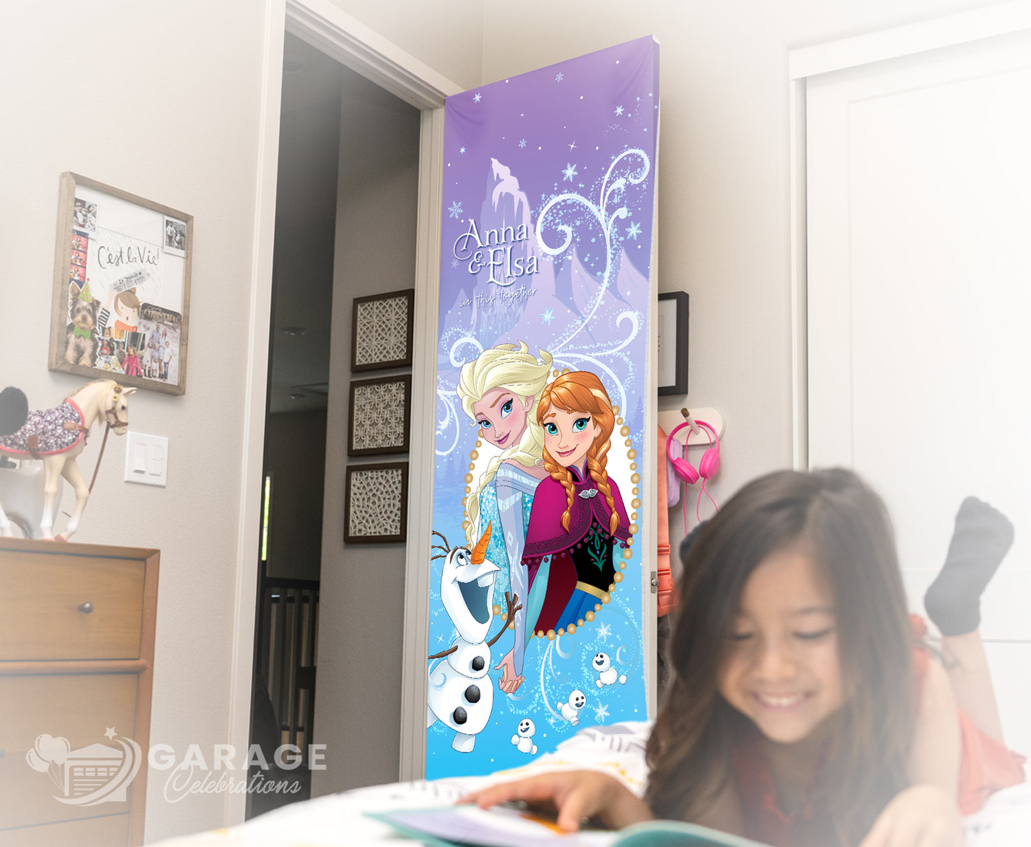 Child reading a book with a 'Frozen' themed door cover in the background. 