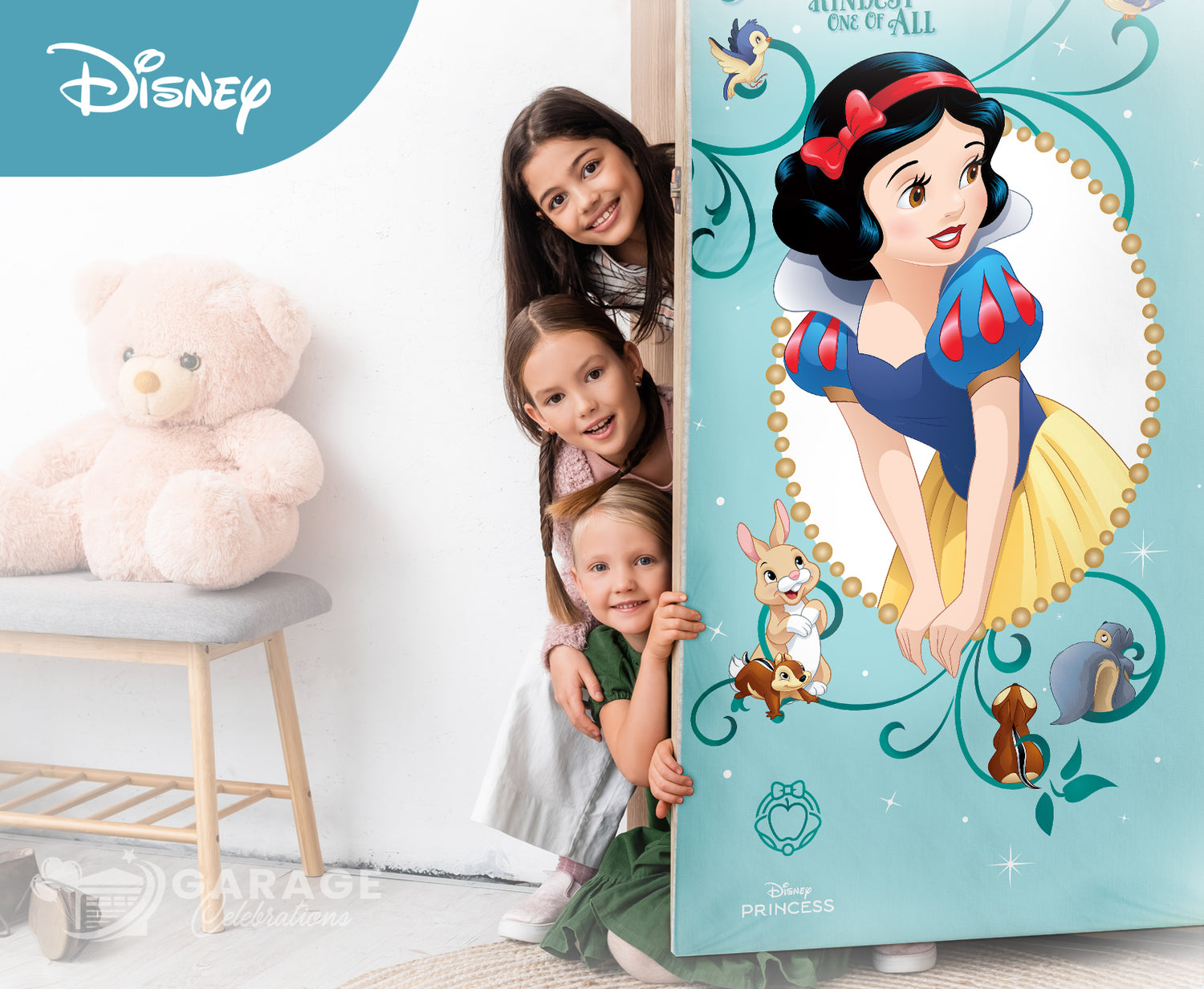 Children peeking from behind a Snow White poster in a room with a teddy bear and shelves.